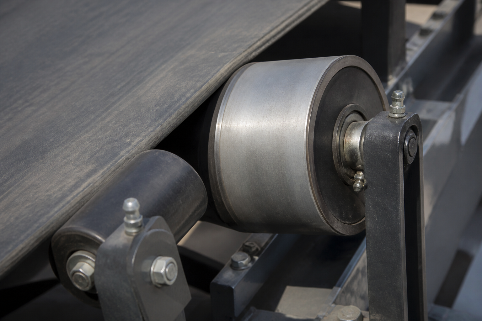 Training idler and belt edge at a crowned pulley