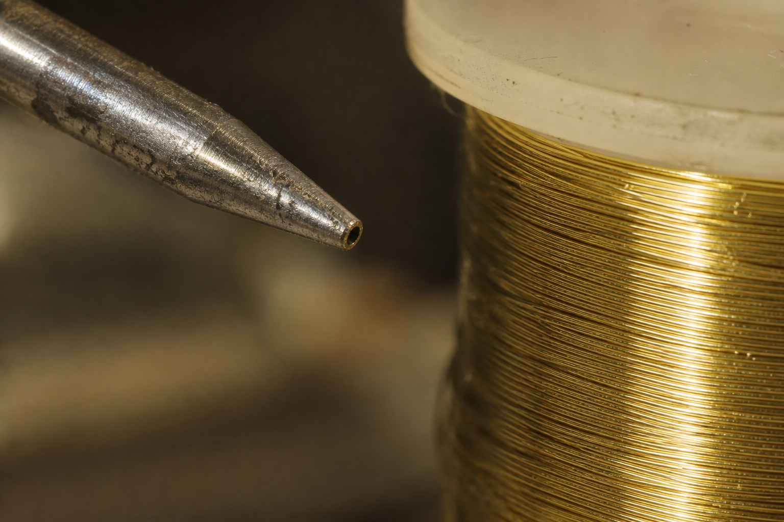Worn wire-bond capillary tip and gold wire under inspection light